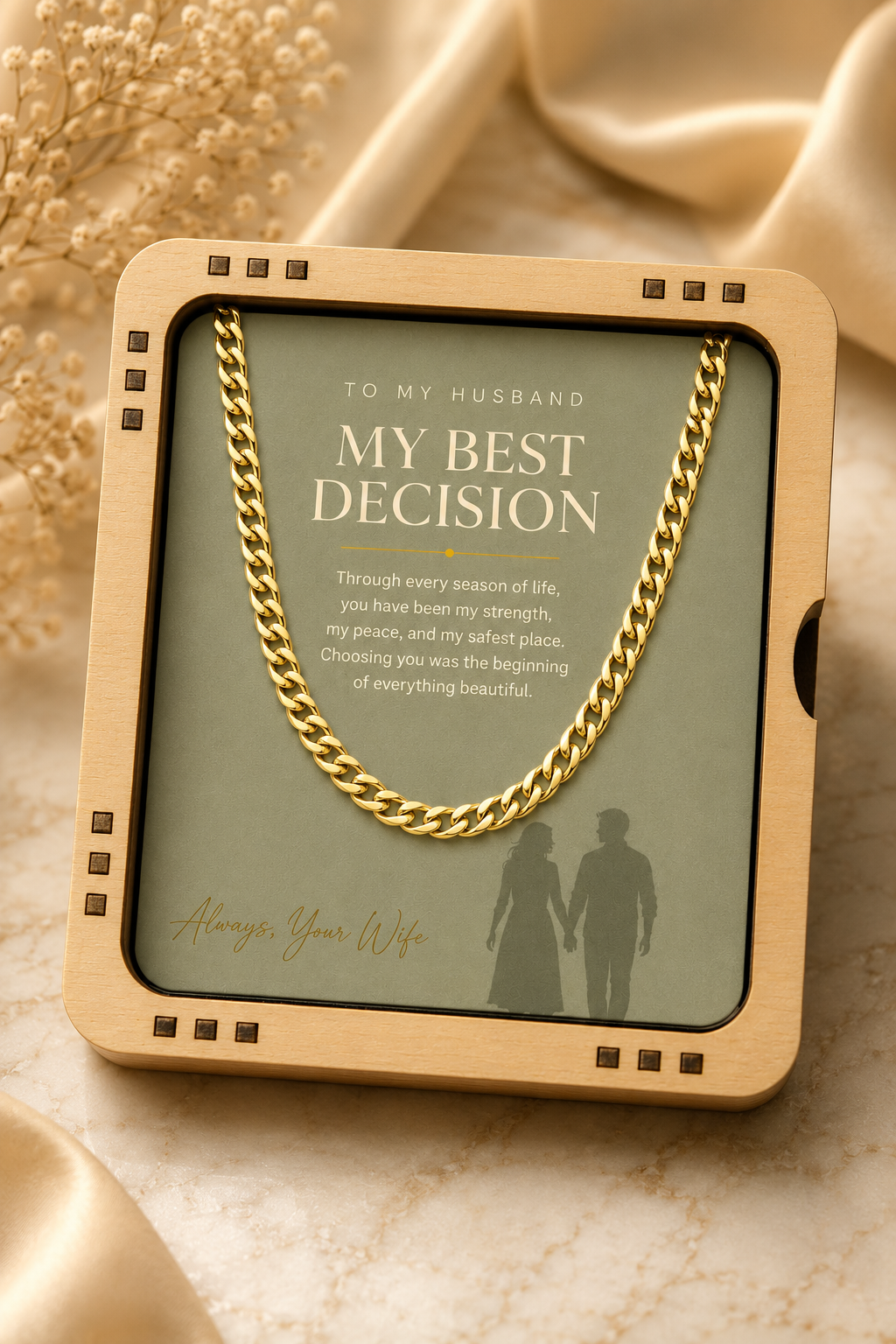 A gold chain necklace presented in a square wooden gift box with a printed card that reads 'TO MY HUSBAND MY BEST DECISION' and a poem, styled on a beige marble surface with soft satin fabric.