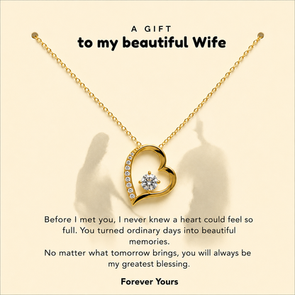 A gold heart-shaped pendant necklace with a small clear gemstone, displayed on a cream background with sentimental text and shadow overlays.