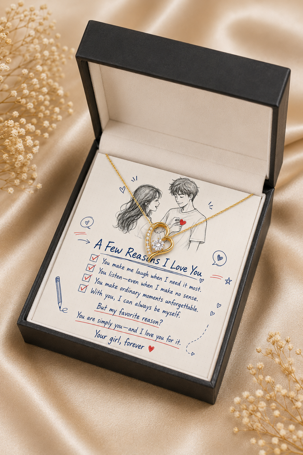 A gold heart-shaped pendant necklace with a delicate chain is presented inside an open black gift box. The necklace rests on a printed message card that reads 'A Few Reasons I Love You' with a sketch of a couple.