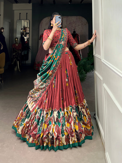 Red Tussar silk lehenga with Kalamkari print work, adorned with vibrant traditional motifs for a bold and festive look.
