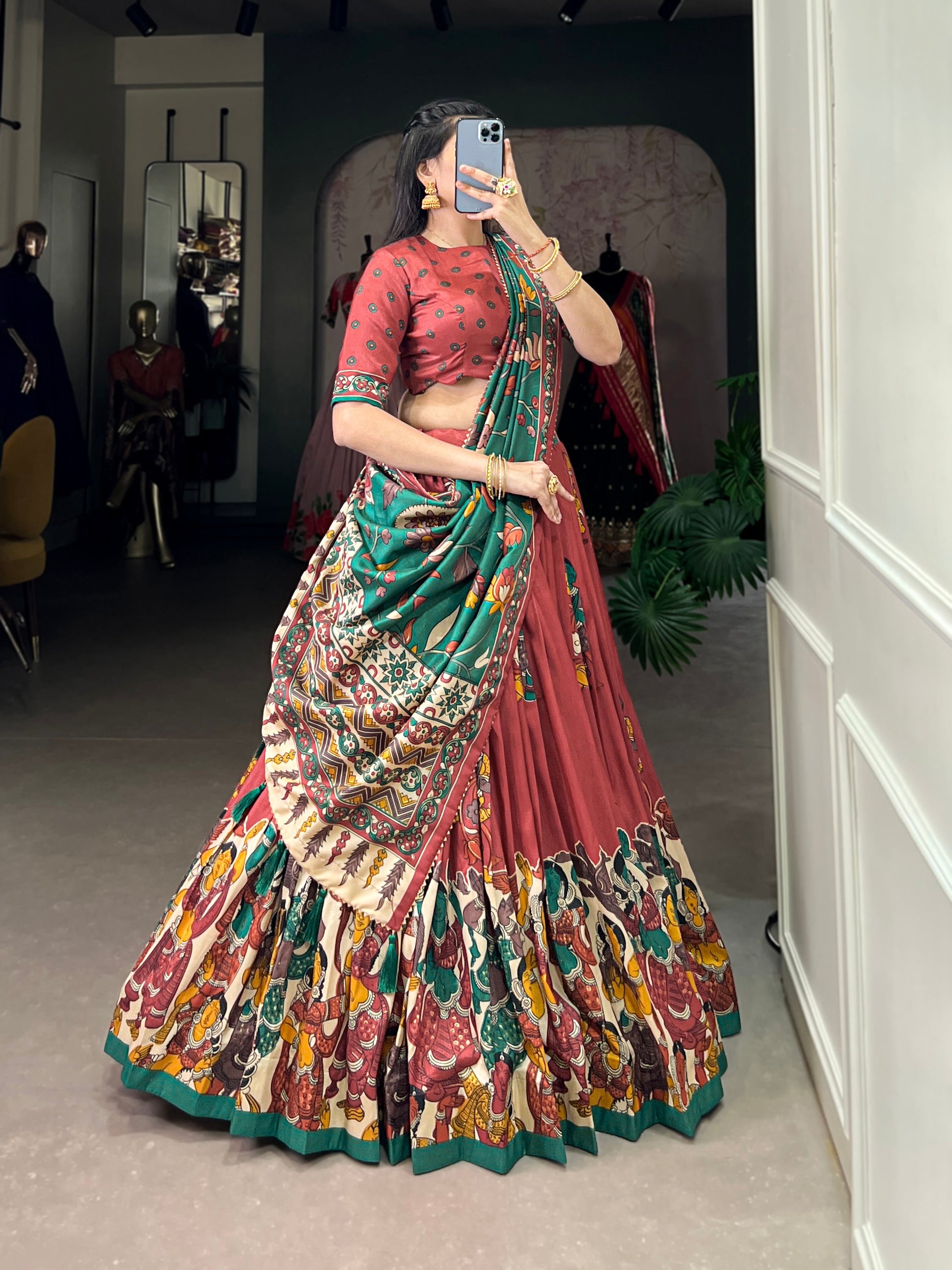 Red Tussar silk lehenga with Kalamkari print work, adorned with vibrant traditional motifs for a bold and festive look.

