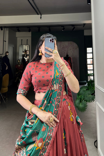Red Tussar silk lehenga with Kalamkari print work, adorned with vibrant traditional motifs for a bold and festive look.
