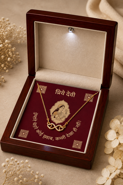 Gold-tone infinity heart necklace with sparkling clear accents on burgundy Hindi message card