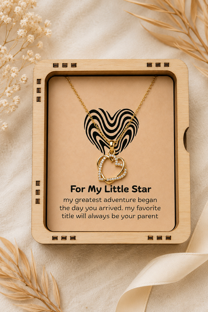 Double heart silver-tone pendant necklace displayed inside illuminated wooden box