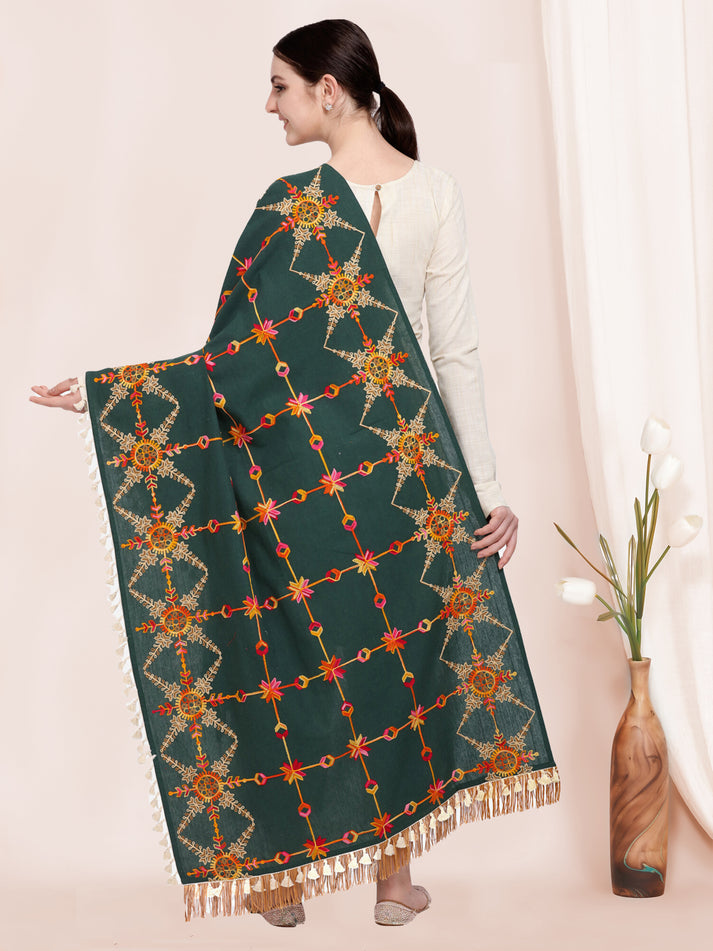 Woman holding a green shawl with intricate patterns