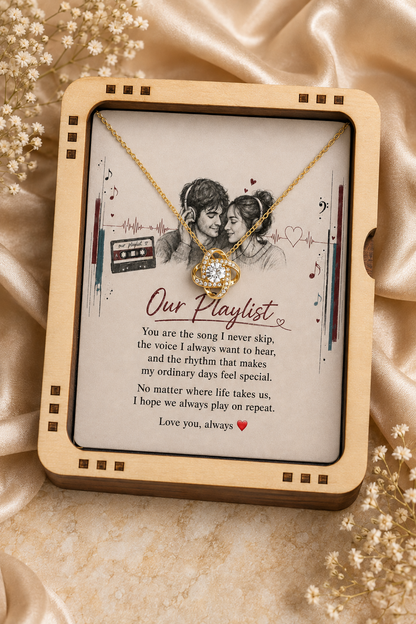 Gold-tone love pendant necklace displayed in a wooden jewelry gift box