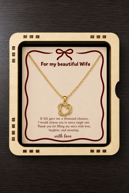 Gold-tone heart pendant necklace arranged inside a black presentation box
