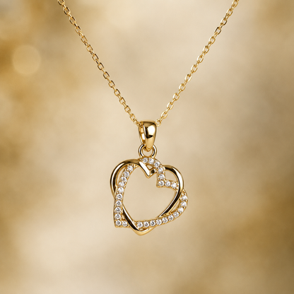 Gold-tone heart necklace with clear stone-style accents and a celestial round pendant