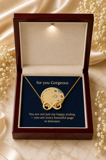 Gold-tone infinity heart pendant necklace with clear stone accents and emotional message card