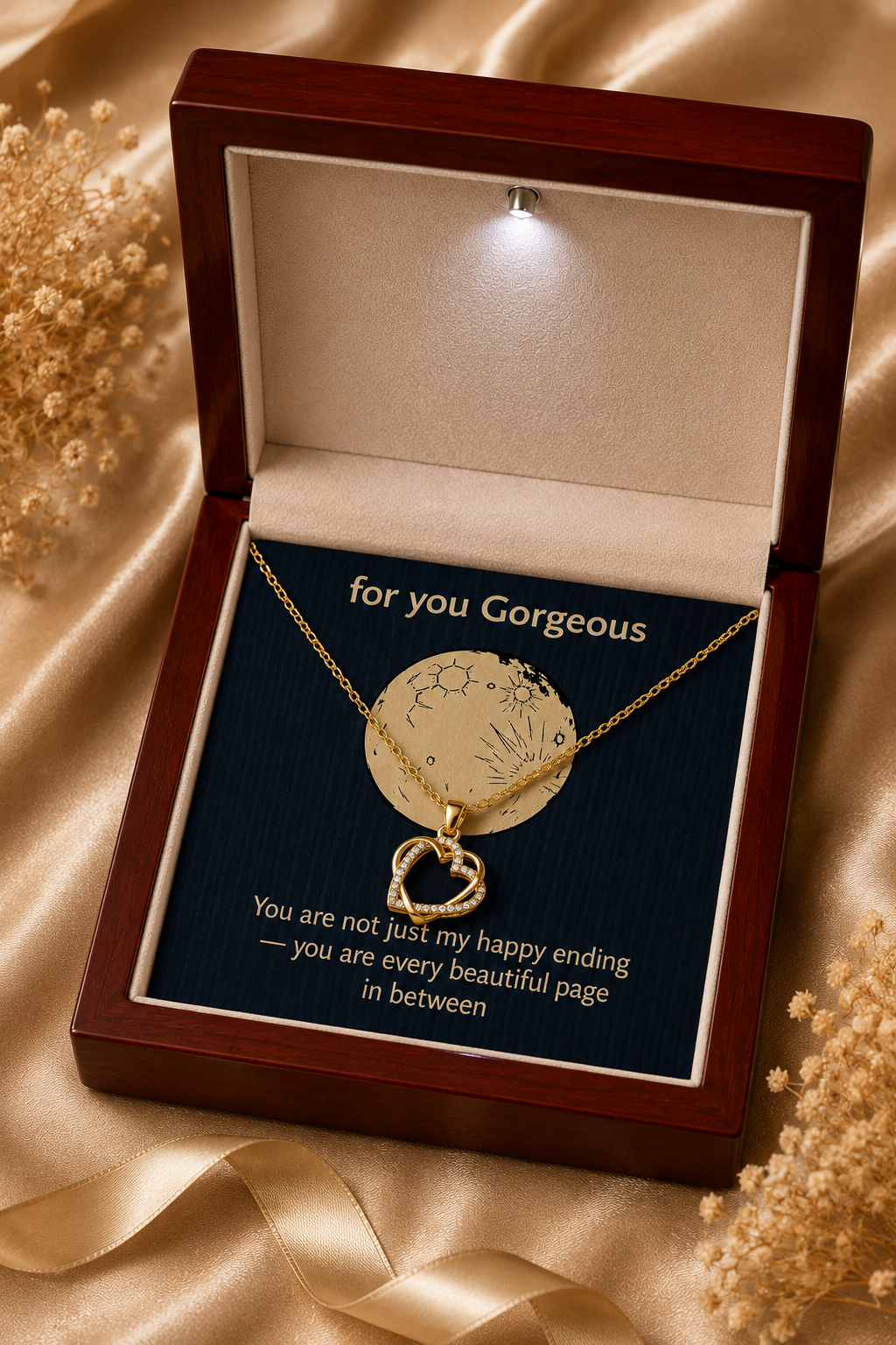 Gold-tone pendant necklace arranged on a dark message card inside a LED wooden presentation box