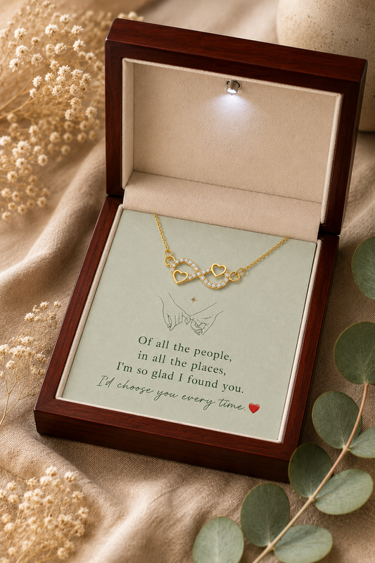 Infinity heart necklace with clear crystal-style accents displayed on an emotional message card