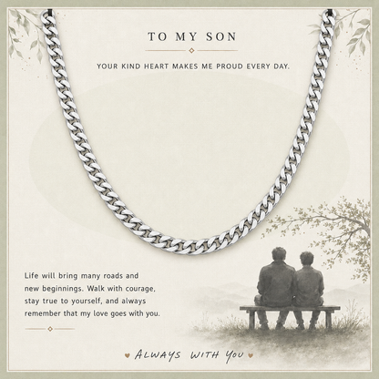 A silver-toned curb chain necklace displayed on a cream-colored sentimental card with printed text and an illustration of two people sitting on a bench.