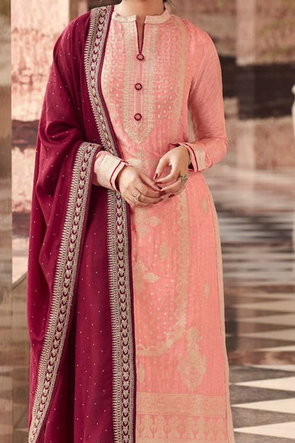 Woman in traditional pink and maroon outfit standing on a checkered floor.