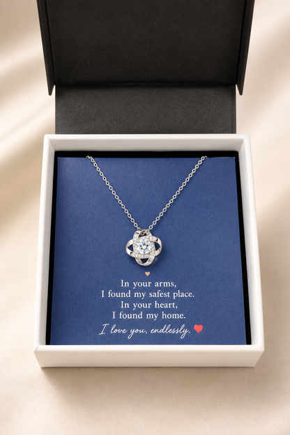 A silver heart-shaped pendant necklace displayed inside an open white gift box with a dark blue insert. The necklace is centered on the box, with a sentimental quote printed on the insert.