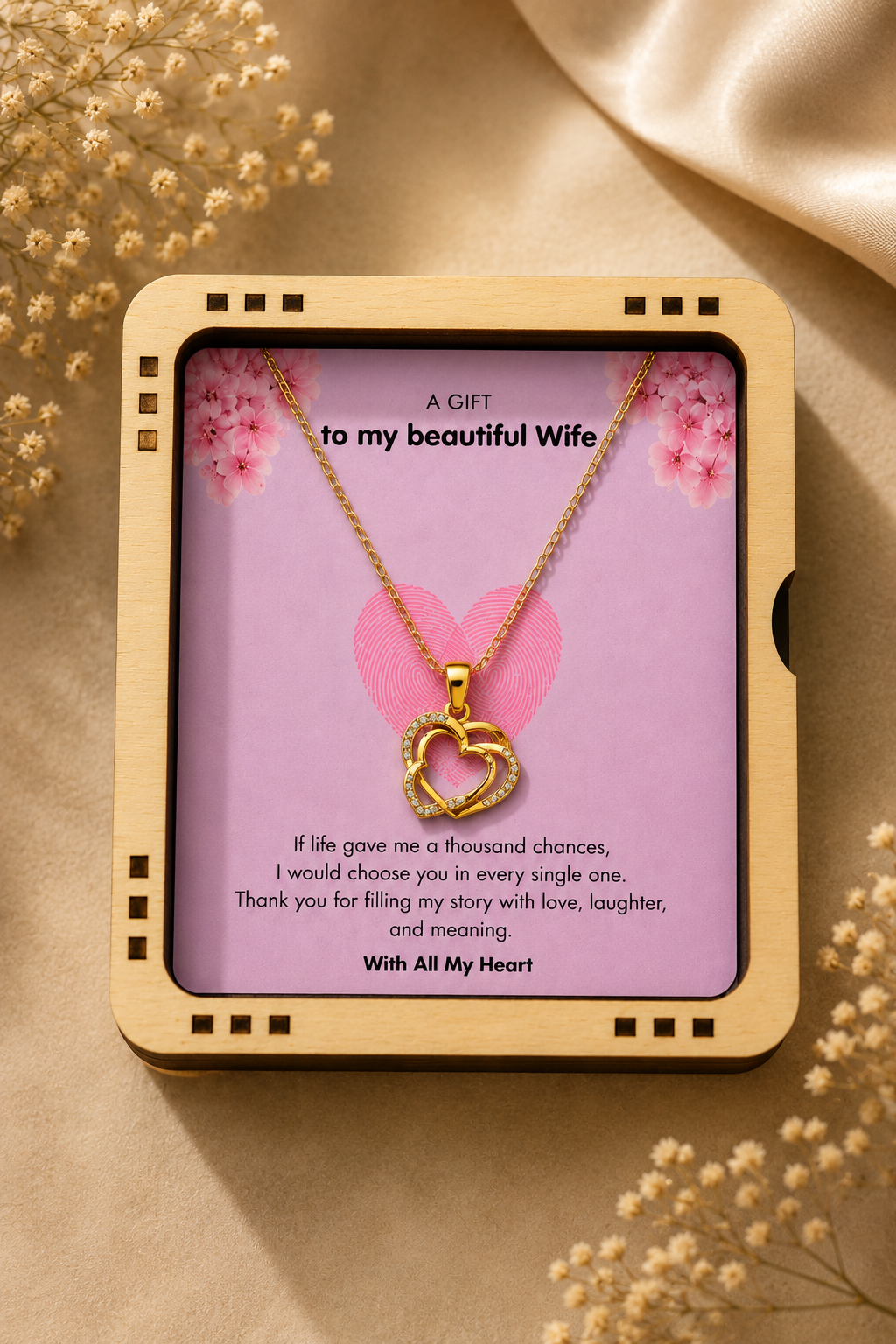 Full view of the gold-tone chain and crystal-accented heart pendant arranged on the greeting card.