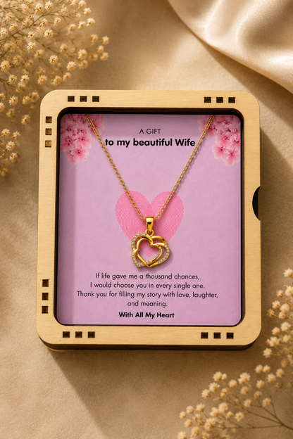 Full view of the gold-tone chain and crystal-accented heart pendant arranged on the greeting card.