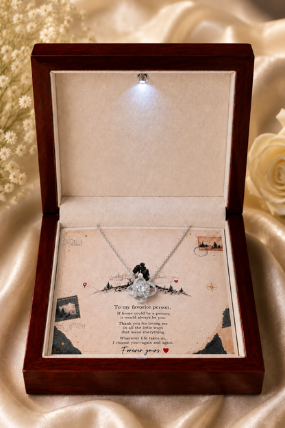 Silver-tone pendant necklace with crystal-style accents shown on a love-themed message card inside a gift box.