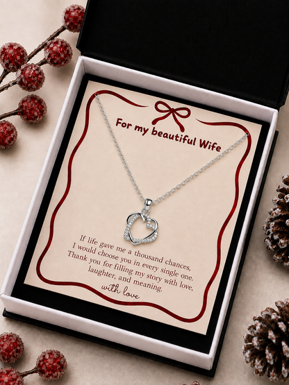 Silver-tone heart pendant necklace arranged inside a black presentation box