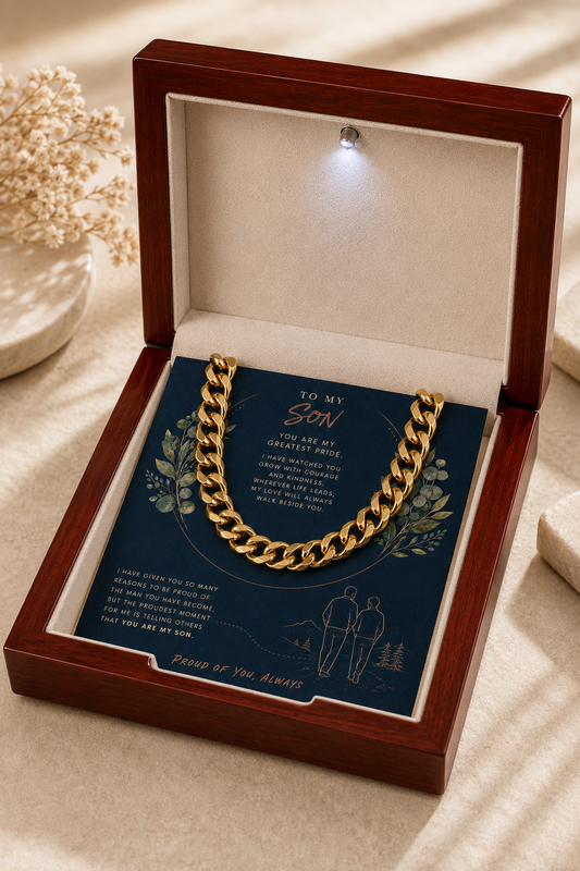 A gold chain necklace presented in an open reddish-brown wooden gift box with a cream interior.