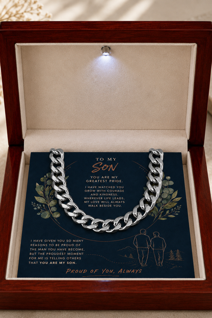 A silver chain necklace presented inside an open wooden gift box with a soft cream interior. 