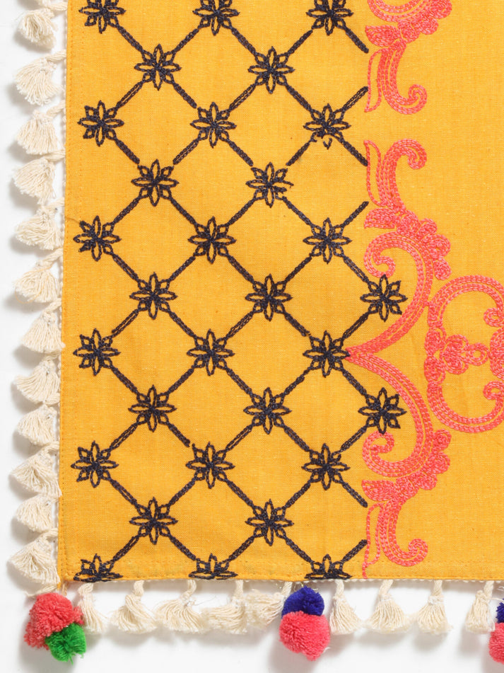 Close-up of a colorful fabric with geometric patterns and tassels.
