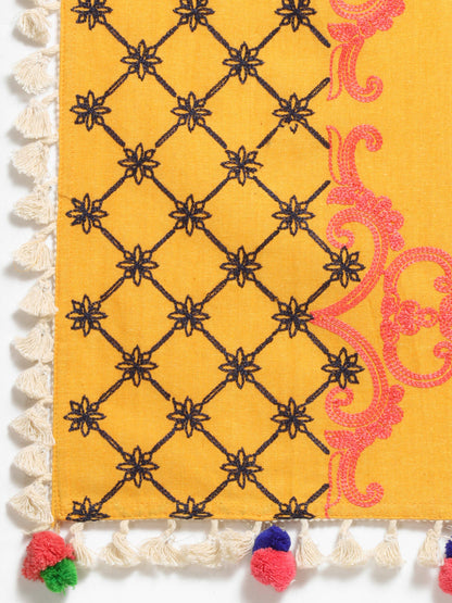 Close-up of a colorful fabric with geometric patterns and tassels.
